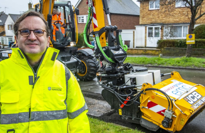 Cllr Osborn stood in front of the Council's new JCB pothole pro machine in a road which has been resurfaced.