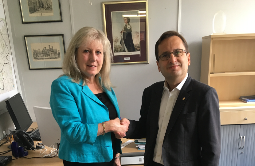 Susan Hall AM and Cllr Paul Osborn stood shaking hands in an office.