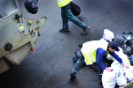 Refuse workers clearing bags of rubbish into a bin lorry