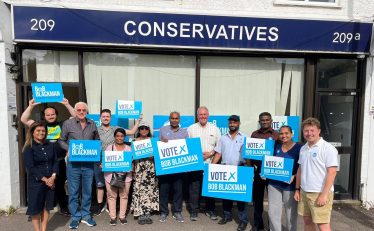 Bob Blackman MP with a team of activists out front the Harrow East Conservative Office holding up Vote Conservative signs