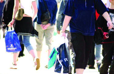 People shopping and carrying bags in a busy high street